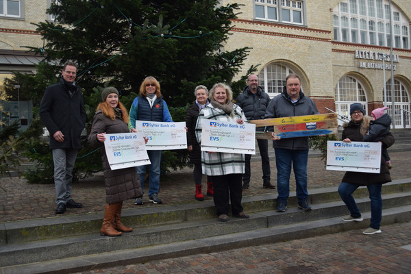 Menschen halten exemplarische Schecks der EVS in den Händen