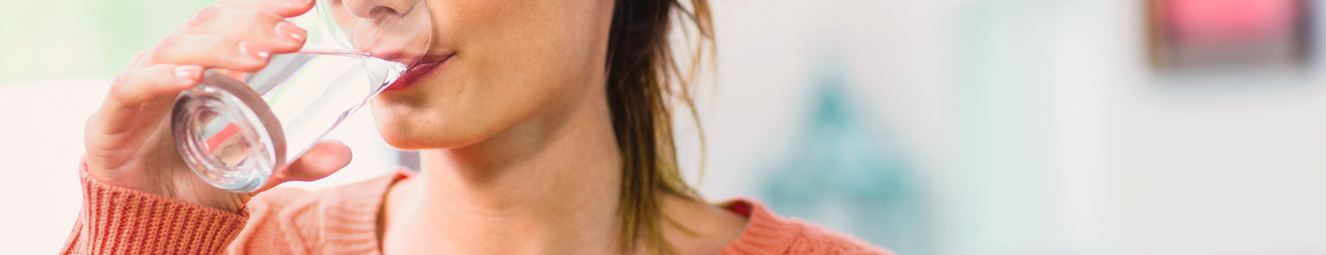 Frau trinkt aus Wasserglas